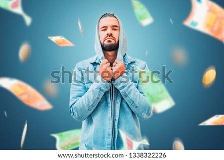 Young man in modern and casual clothes on bottom with money flying