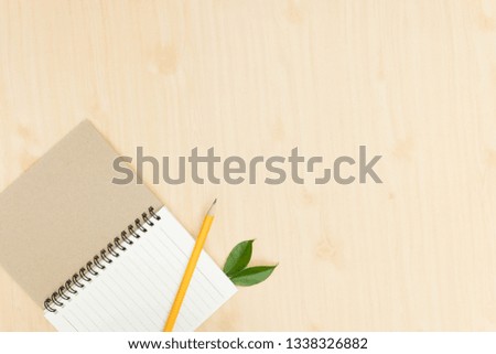 yellow pencil with notebook on wooden desk,flat lay. Top view.