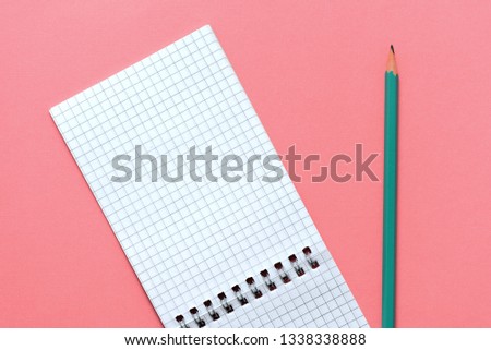 Blank notepad with pencil on pink background close up