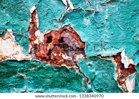 Background texture relief structure age-related changes in metal corrosion chipped cracks cracking rust pieces peeling erosion peeling green paint with white and red inserts wall surface large fragmen Royalty-Free Stock Photo #1338340970