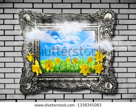 Nature concept. Abstract natural spring background with grass and narcissus in frame. Spring field under sunny sky. Clouds and flowers coming out of frame. Picture in frame on brick wall.