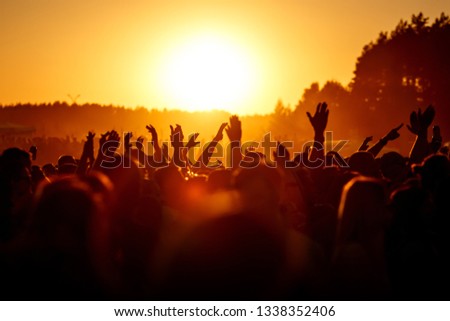 People celebrating on an summer open air. Shillouettes of raised hands Royalty-Free Stock Photo #1338352406