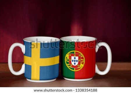 Portugal and Sweden flag on two cups with blurry background