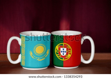 Portugal and Kazakhstan flag on two cups with blurry background