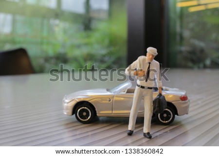 the small figure with the toy sport car