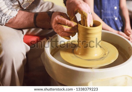 the master with the child molds a clay jug