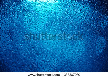 Many blue water drops on window glass. colorful bubbles  background