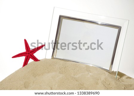 empty glasses Photo frame and red sea star stands on the sand isolated on white  background. 