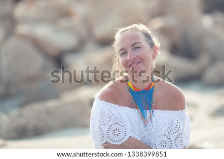 portrait of a beautiful woman on the background of the sea and stones