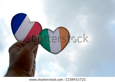 Hand holds a heart Shape France and Ireland flag, love between two countries