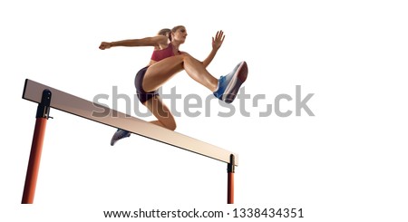 Isolated Female Track and field athlete jumps over the barrier on white background