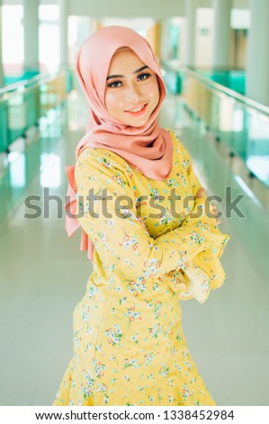 Portraiture of young arabic muslim woman in head scarf smile posing for a camera