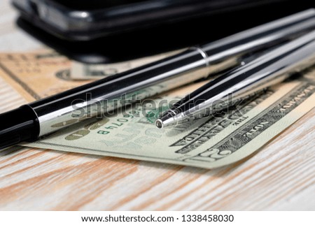 Set of pens, phone and bills on a light background closeup. Shallow depth of field