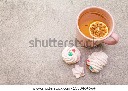 Romantic sweet breakfast concept. Green tea, lemon, meringue (cake). On stone background