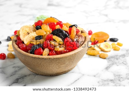 Bowl with different dried fruits on marble background. Healthy lifestyle