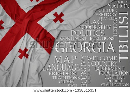 waving colorful national flag of georgia on a gray background with important words about country . concept