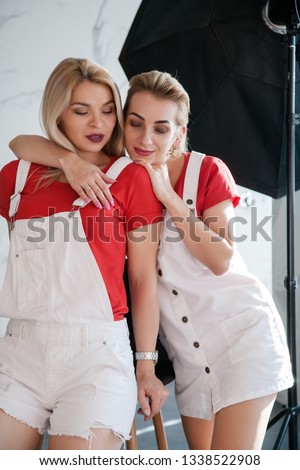 Backstage photography in progress. Close family relationship. Two sisters hugging.