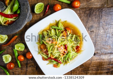Cooking Thai food, papaya salad and papaya salad in a dish with a serving on a wooden table.