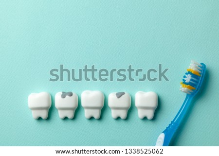 Healthy white teeth and tooth with caries on green mint background and Toothbrush