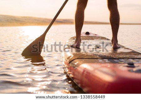 Person on paddle board at sunset Royalty-Free Stock Photo #1338558449