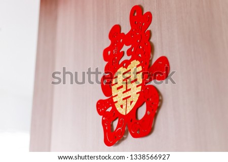 Chinese wedding symbol paper cut stick on the door of bride's room. Chinese Wedding with Double Happiness Text Calligraphy Illustration on paper cut design.
