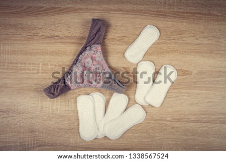 Daily panty liners on wooden background close-up. Discrete panty liner or pad for woman. Intimate hygiene. Woman hygiene protection. Women's health. Feminine pads. Critical days. 