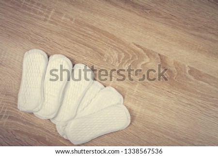 Daily panty liners on wooden background close-up. Discrete panty liner or pad for woman. Intimate hygiene. Woman hygiene protection. Women's health. Feminine pads. Critical days. 