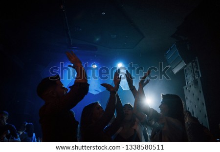We are awesome. Group of people that enjoying dancing in the nightclub with beautiful lightings.