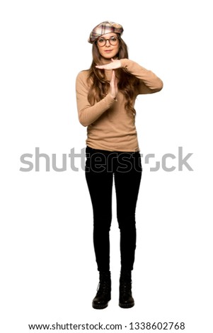 Full-length shot of Young woman with beret making stop gesture with her hand to stop an act on isolated white background