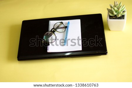 Flat lay view of office table desk. Workspace with keyboard, pen, book, coffee and decoration flower on yellow background. Copy Space concept