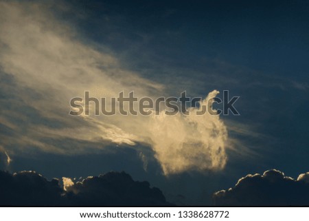 wall of clouds with edges illuminated, in the background blue sky with curtain of white clouds dissolving, sao paulo, brazil