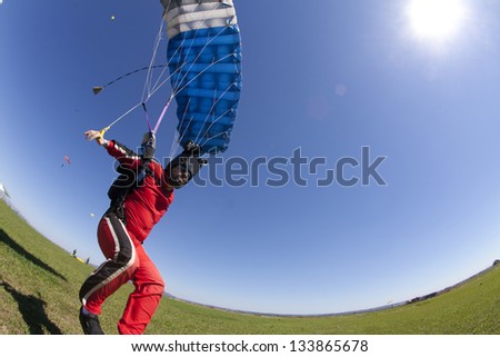 Skydive extreme landing in blue sky
