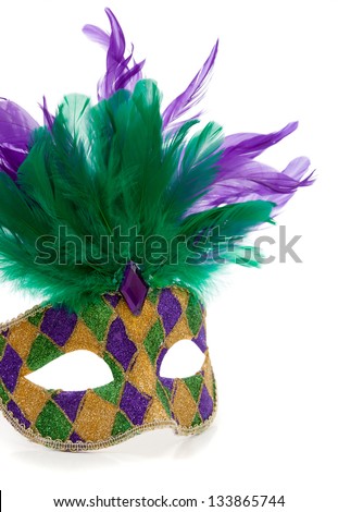 A purple, gold and green Mardi gras mask with feathers on a white background