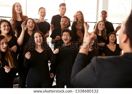 Male And Female Students Singing In Choir With Teacher At Performing Arts School Royalty-Free Stock Photo #1338680132