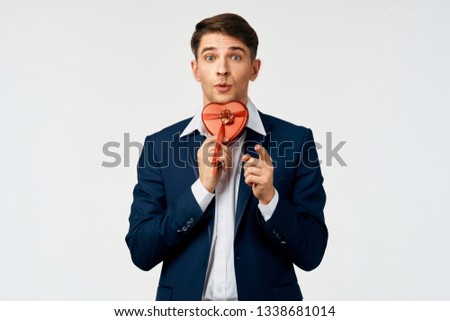 Cheerful handsome business man in a suit with a gift in the hands of a holiday