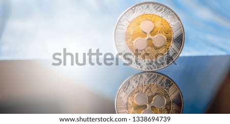 Golden Ripple XRP golden cryptocurrency coin lying on a dark  background with copy space