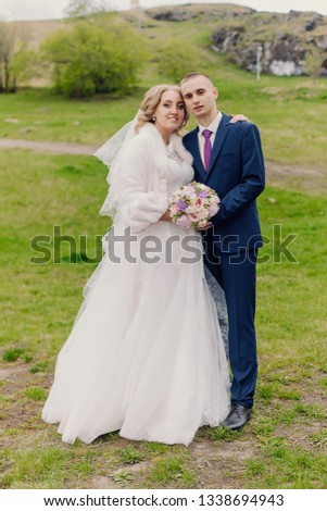 Autumn portrait of newlyweds in love, on a background of green trees on nature. Wedding photography.