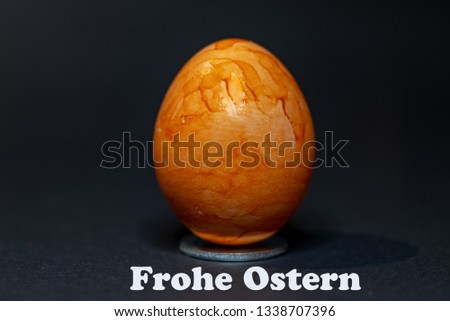 Arrangement of several colorful eggs for Easter against black background.With the text Happy Easter in German.