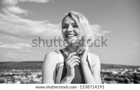Flirt and coquette concept. Girl playful mood coquette. Ultimate art of seduction. Girl blonde lady smiling enjoy freedom and fresh wind blue sky background. Woman red dress feels carefree and free.