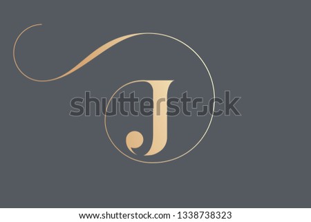 Letter J logo.Typographic icon in golden color isolated on dark background.Serif uppercase lettering.Initial character with round frame and swirl.Luxury style sign. Royalty-Free Stock Photo #1338738323