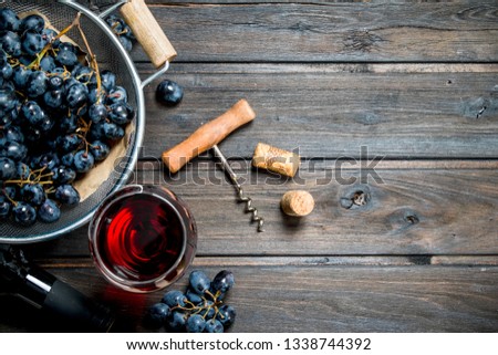 Wine background. Red wine in glasses with grapes. On a wooden background.