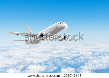 Airplane is flying above the day clouds, travel trip vacation Royalty-Free Stock Photo #1338749645