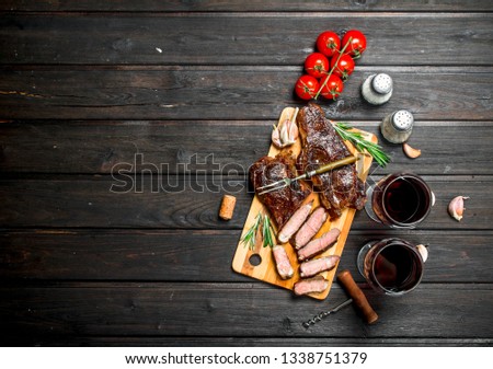 Grilled beef steak with red wine. On a wooden table.