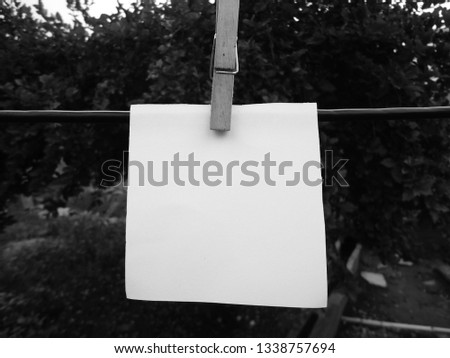 Cropped blank note hanging on a clothesline with clothespin