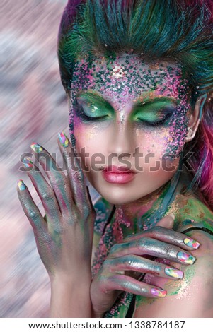 close up  portrait of young beautiful girl with colorful face painting with beads. Halloween professional makeup. hair in paint. beauty portrait. colorful lush hairdo