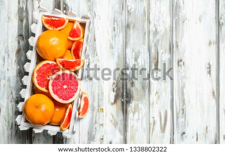 Ripe grapefruit in the box. On wooden background