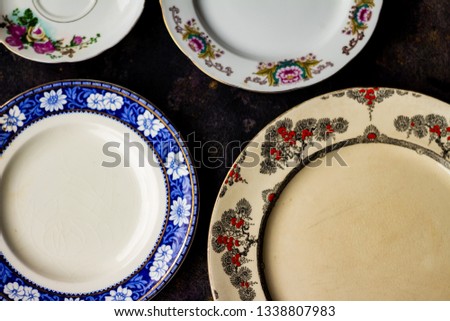 Finely decorated antique dishes on black background. Free space to write. Collection tableware Royalty-Free Stock Photo #1338807983