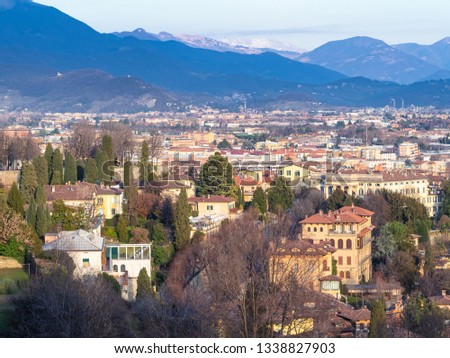 Travel to Italy - above view of residential quarters of Lower Town (Citta Bassa) with Alps mountains on horizon from Porta San Giacomo gate in Bergamo city, Lombardy in evening