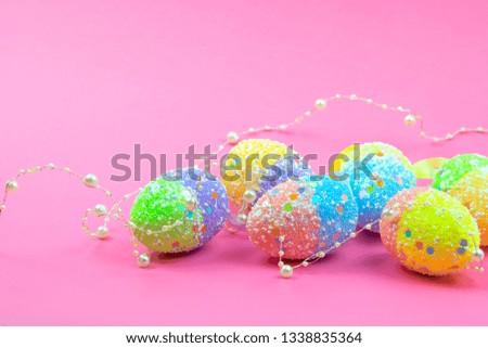 A lot of colorful Easter eggs on a pink background. Place for the inscription.