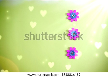 beautiful minimal bright colorful close up top view flat lay photo of small fake flowers on bright background with copy space and magical shiny  old school retro effects of light and bokeh 